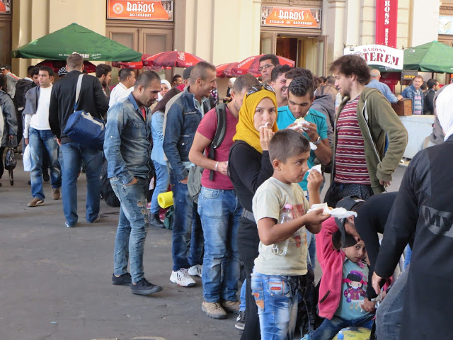 Fila d'immigrati in attesa del treno per Vienna