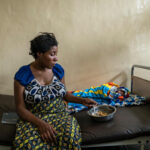 Shekinah*, 26, eats lunch 3 days after delivering her baby Muhindo*,  at the hospital where she gave birth by caesarean section with the support of Save the Children in Goma, North Kivu province, Democratic Republic of Congo